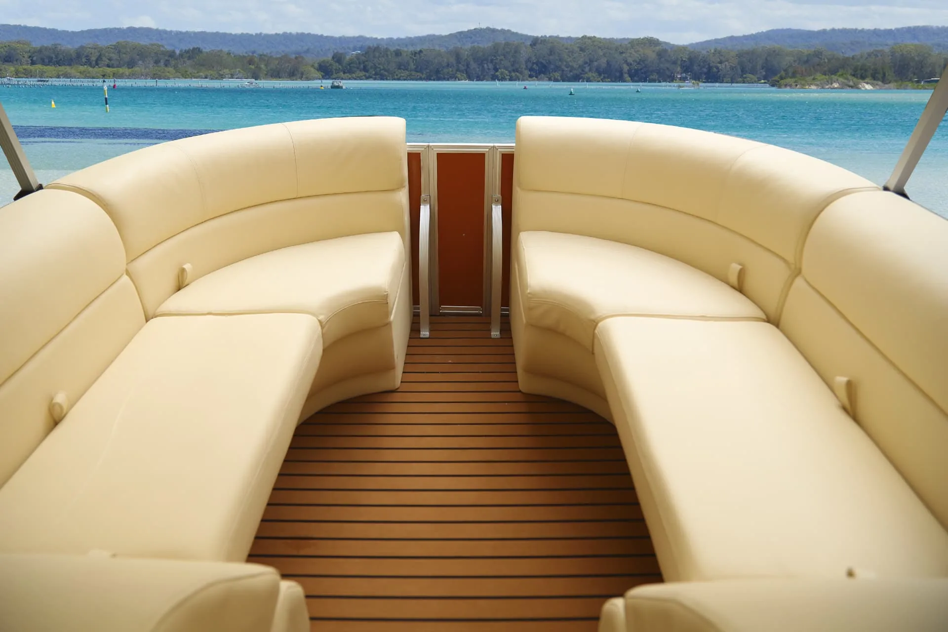 Facing cream-colored pontoon lounges with a center walkway and bow gate